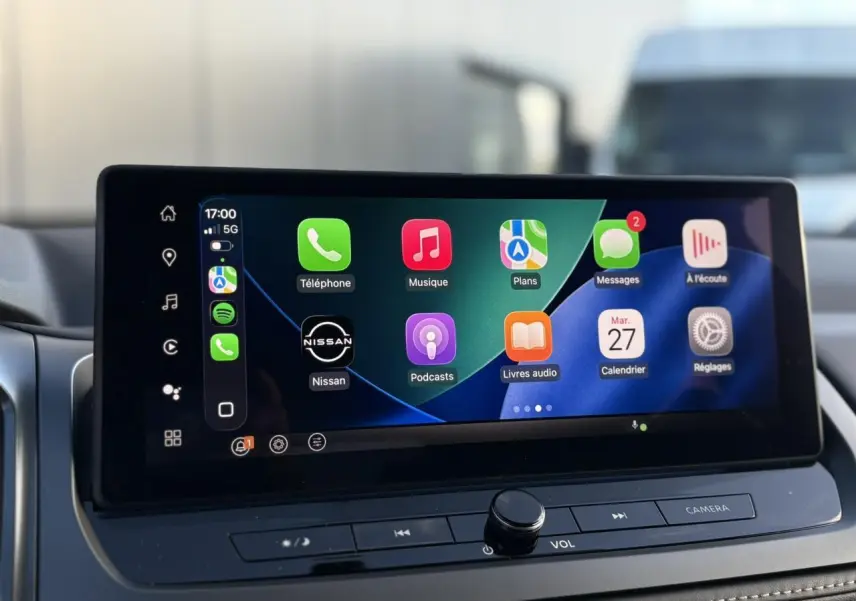 Écran tactile central du Nissan Qashqai III en gros plan, affichant Apple CarPlay avec icônes colorées.
