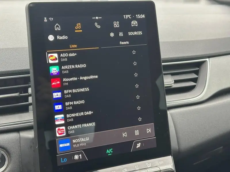Vue rapprochée de l’écran tactile central du tableau de bord du Renault Captur 2025, affichant les radios DAB.