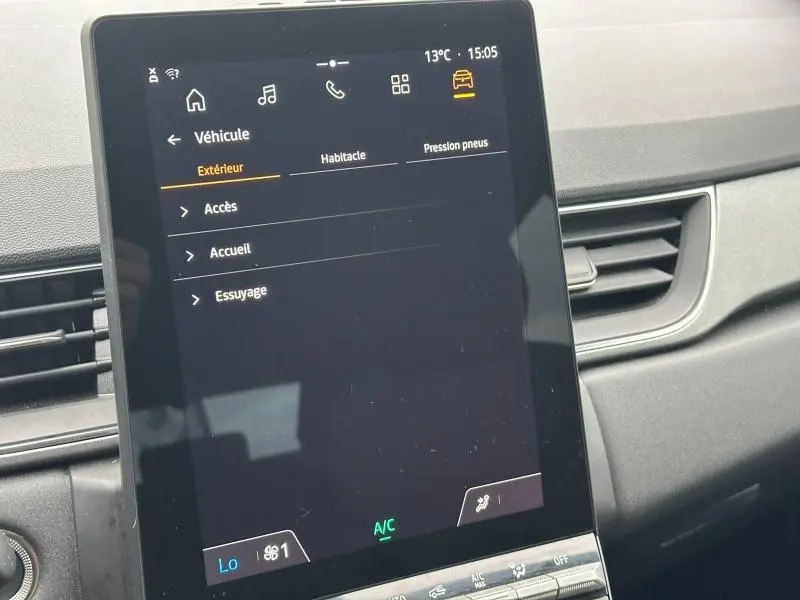 Écran tactile central du tableau de bord du Renault Captur 2025, affichant le menu véhicule en intérieur noir.