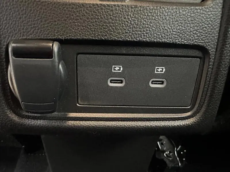 Gros plan sur deux ports USB-C de recharge rapide dans l'habitacle noir du Renault Captur 2025.