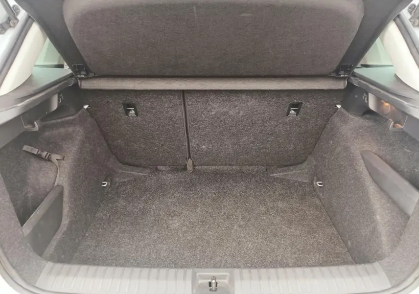 Coffre ouvert vu de l'arrière d'un Skoda Kamiq 2025, intérieur spacieux et revêtement gris foncé.