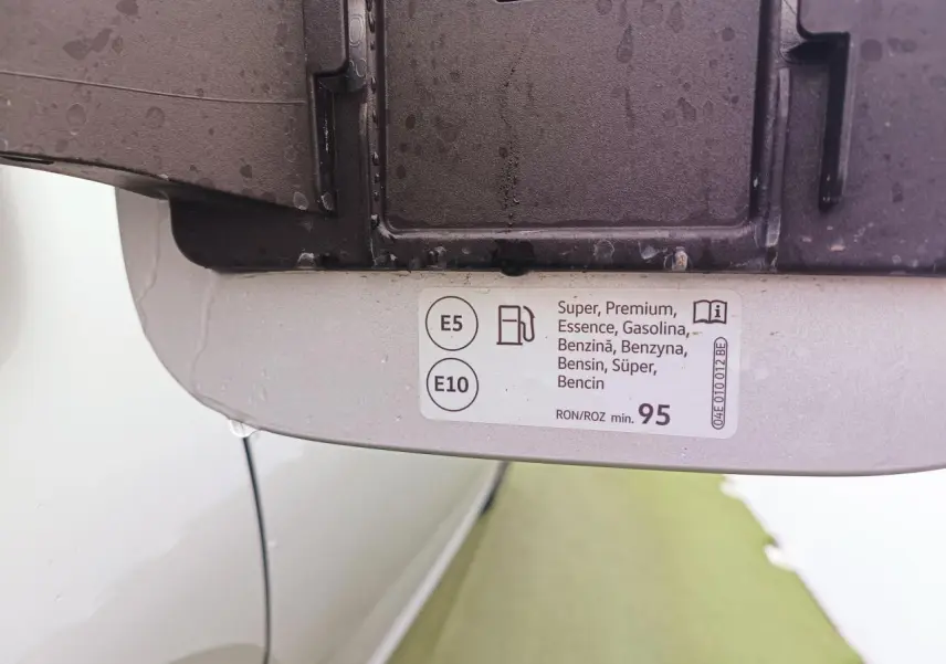 Vue rapprochée de l'intérieur de la trappe à carburant d'une Skoda Kamiq argent avec toit noir, étiquette essence E5 et E10 visible.