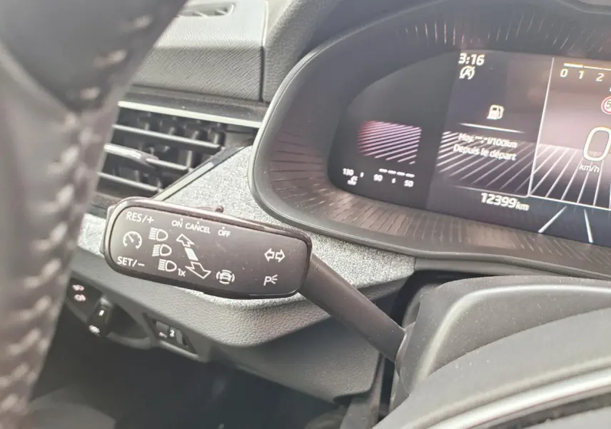 Gros plan sur la commande du régulateur de vitesse à gauche du volant dans un Skoda Kamiq 2025 au tableau de bord numérique.