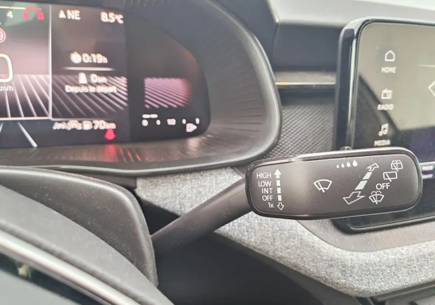 Gros plan sur la commande d’essuie-glace dans l’habitacle gris d’un Skoda Kamiq 2025 avec tableau de bord numérique.