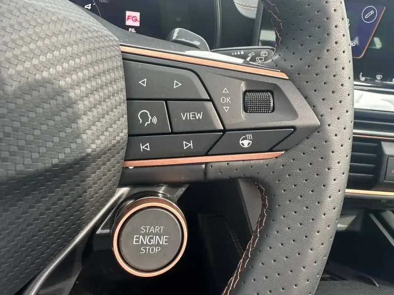 Gros plan sur le volant perforé de la CUPRA Formentor 2.0 TDI 150ch 2026 avec commandes multifonctions et bouton start/stop noir et cuivre.