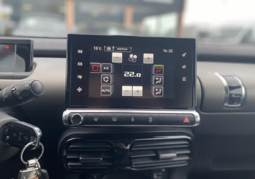Vue rapprochée du tableau de bord de la Citroën C4 Cactus 2015, écran tactile affichant la climatisation à 22°C.