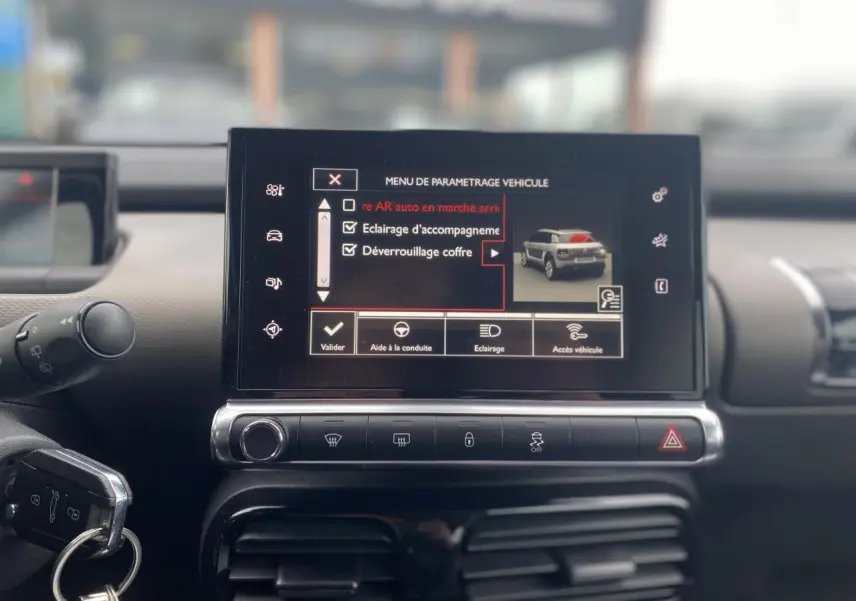 Vue intérieure du tableau de bord de la Citroën C4 Cactus blanc, avec écran tactile affichant le menu de paramétrage véhicule.
