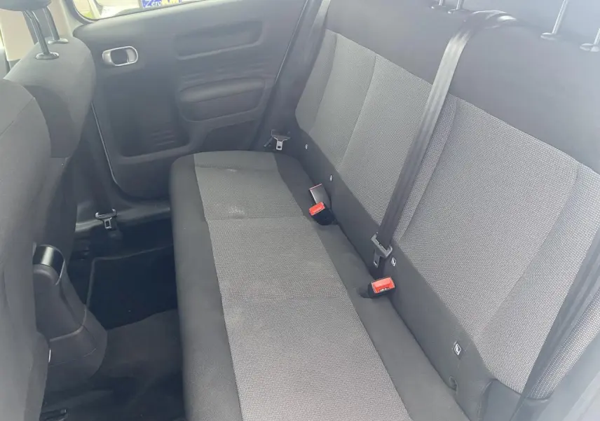 Vue intérieure montrant la banquette arrière grise et noire de la Citroën C4 Cactus, côté droit, avec ceintures de sécurité visibles.