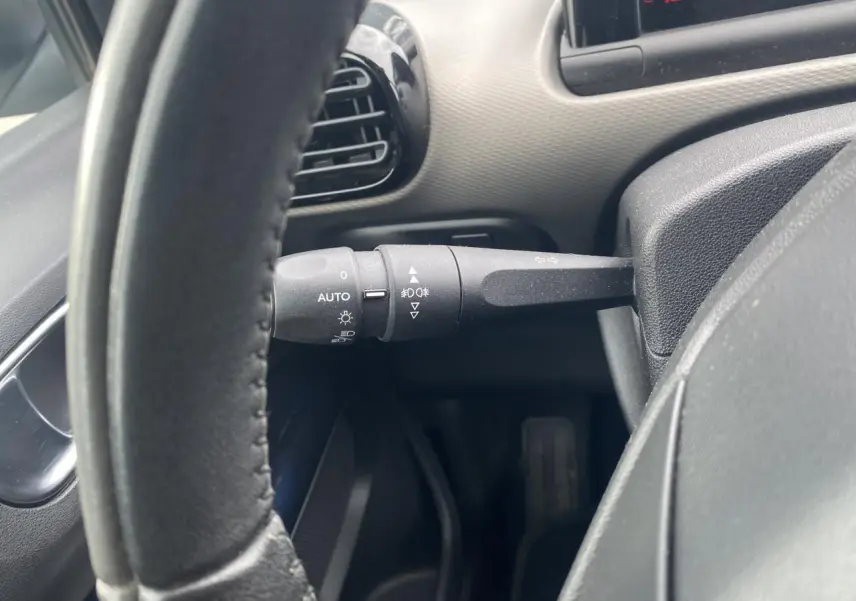 Vue rapprochée du commodo d'éclairage à gauche du volant d'une Citroën C4 Cactus blanche de 2015.