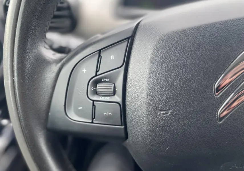 Gros plan sur le volant noir de la Citroën C4 Cactus 2015 avec commandes de régulateur de vitesse intégrées.