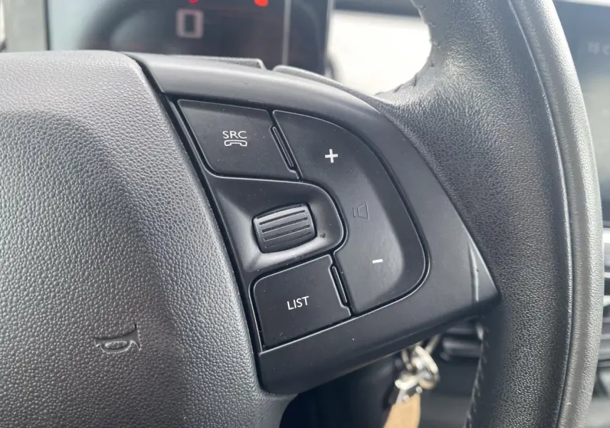 Gros plan sur les commandes au volant noir de la Citroën C4 Cactus blanche, côté droit du volant.