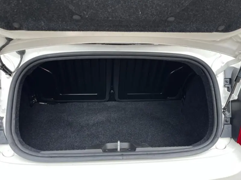 Coffre ouvert vu de dessus d'une FIAT 500C blanche de 2020, montrant l'espace de rangement vide et la bordure noire.