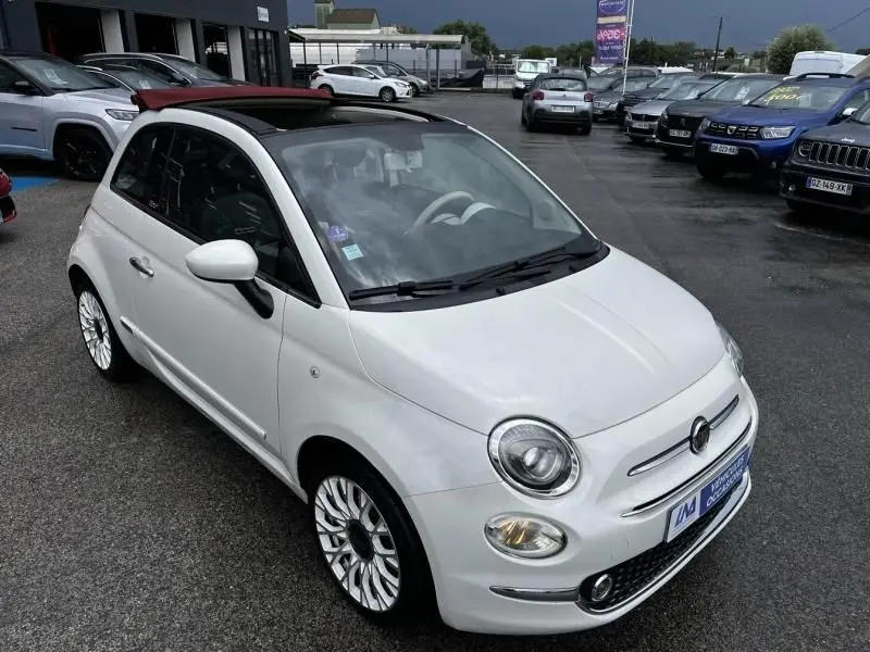 Vue 3/4 avant droite d'une FIAT 500C blanche 2020 avec toit ouvrant noir et jantes multibranches distinctives.