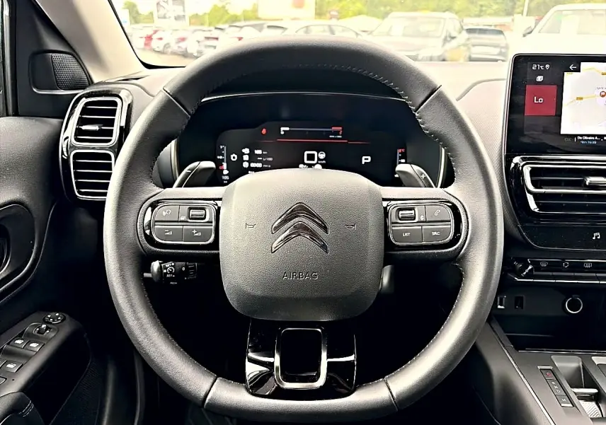 Vue intérieure centrée sur le volant cuir noir multifonction du Citroën C5 Aircross 2025 avec écran tactile et tableau de bord numérique.