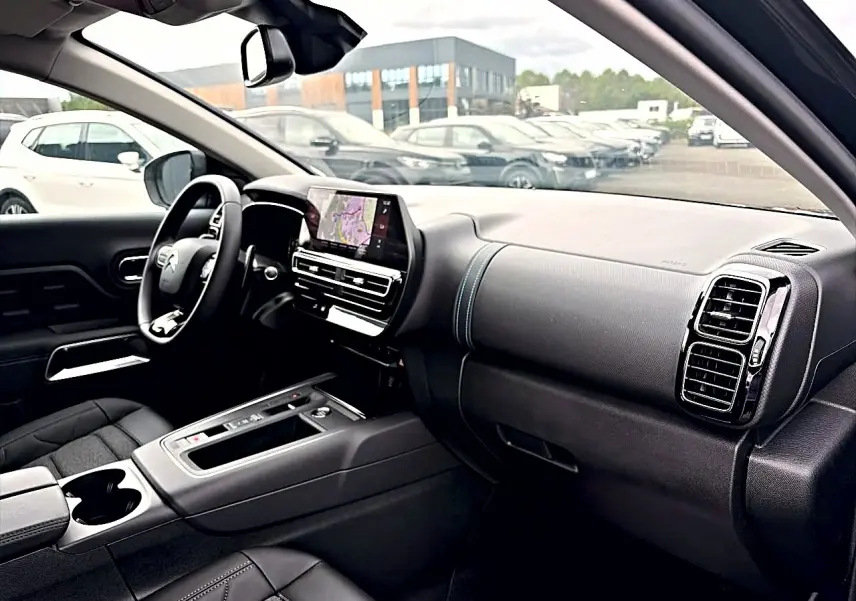Intérieur noir du Citroën C5 Aircross 2025 vu côté conducteur, avec tableau de bord et écran tactile central.