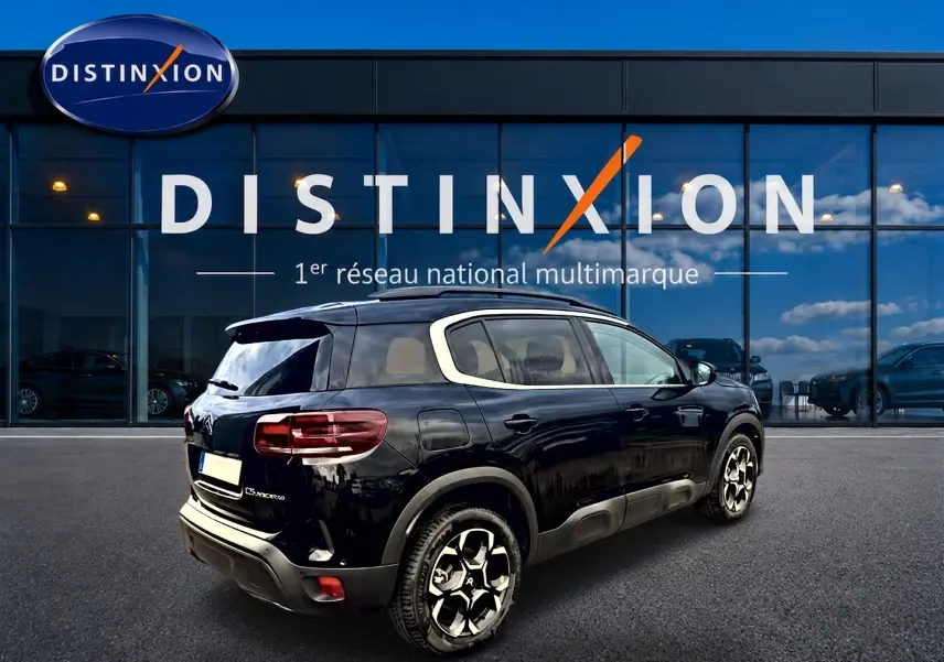 Citroën C5 Aircross noir vue 3/4 arrière droit, avec barres de toit et jantes alliage distinctives.