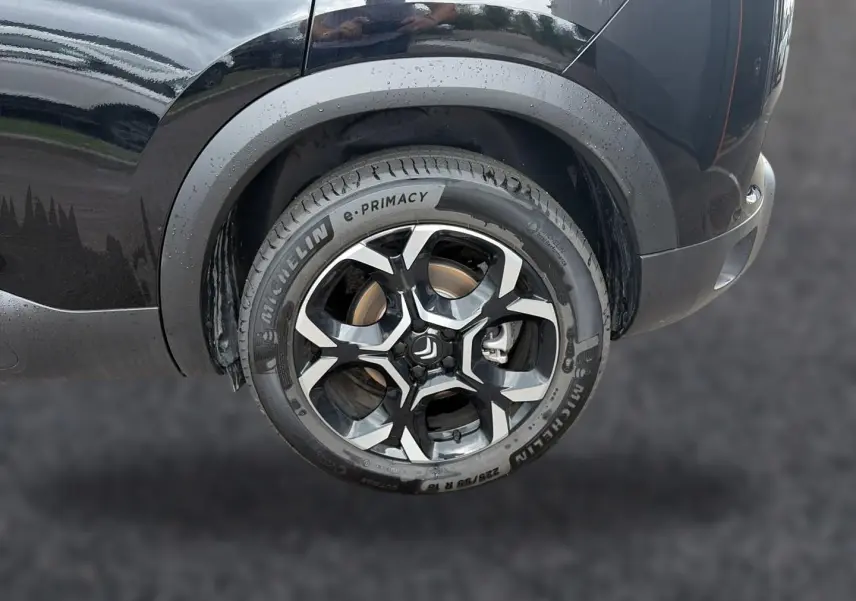 Gros plan sur la roue arrière droite noire d’un Citroën C5 Aircross 2025 avec jante alu bicolore et pneu Michelin.