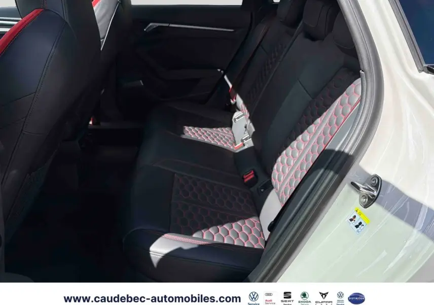 Vue côté droit de l'intérieur arrière de l'Audi RS3 Sportback avec sièges cuir noir à surpiqûres rouges en nid d'abeille.