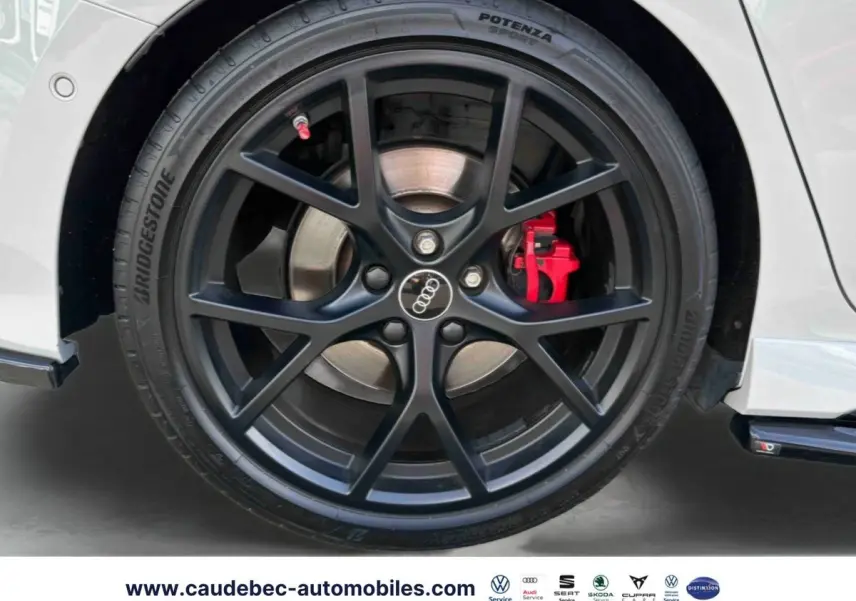 Gros plan sur la jante noire mat à 5 branches en Y de l'Audi RS3 Sportback avec étrier de frein rouge visible.