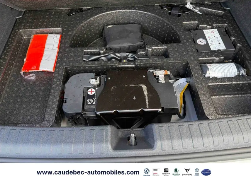 Vue du compartiment sous le coffre de l'Audi RS3 Sportback 2022, montrant la batterie et les outils de bord.