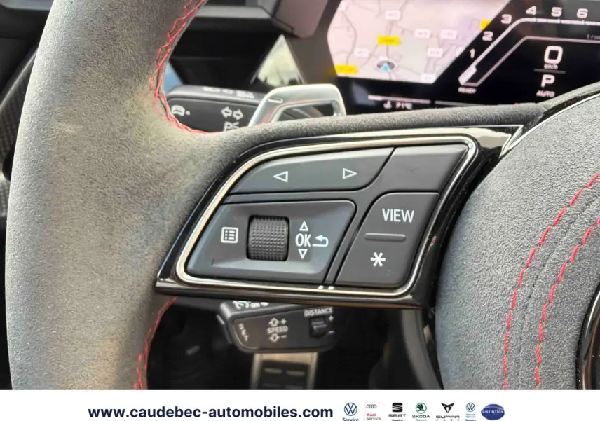 Gros plan sur les commandes du volant en alcantara gris avec surpiqûres rouges de l'Audi RS3 Sportback 2022.