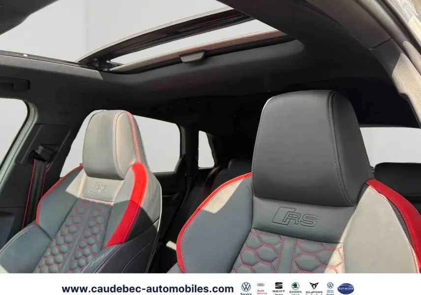Vue intérieure des sièges avant en cuir gris et rouge avec surpiqûres RS et toit panoramique ouvrant de l'Audi RS3 Sportback.