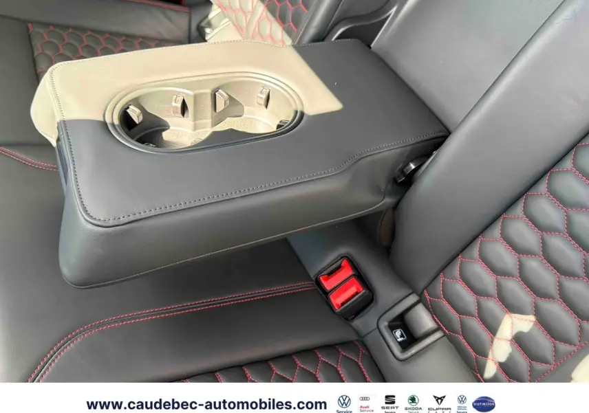 Détail de l'accoudoir central arrière en cuir noir avec surpiqûres rouges sur les sièges de l'Audi RS3 Sportback grise.