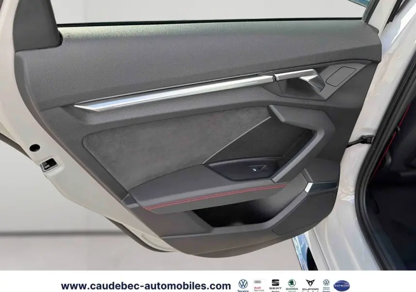 Vue rapprochée de la porte arrière gauche grise de l'Audi RS3 Sportback avec surpiqûres rouges et insert noir mat.