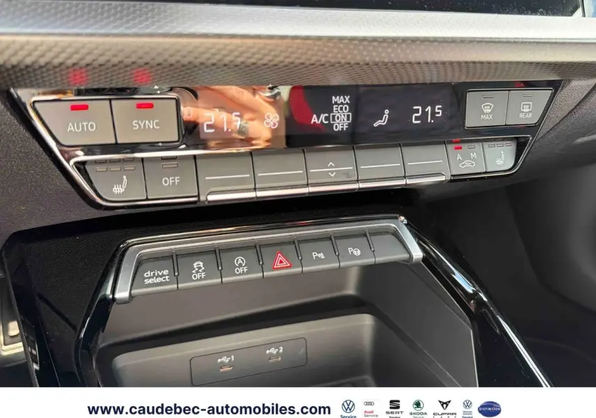 Détail du tableau de bord de l’Audi RS3 Sportback 2022 montrant les commandes de climatisation et les boutons multifonctions en noir brillant.