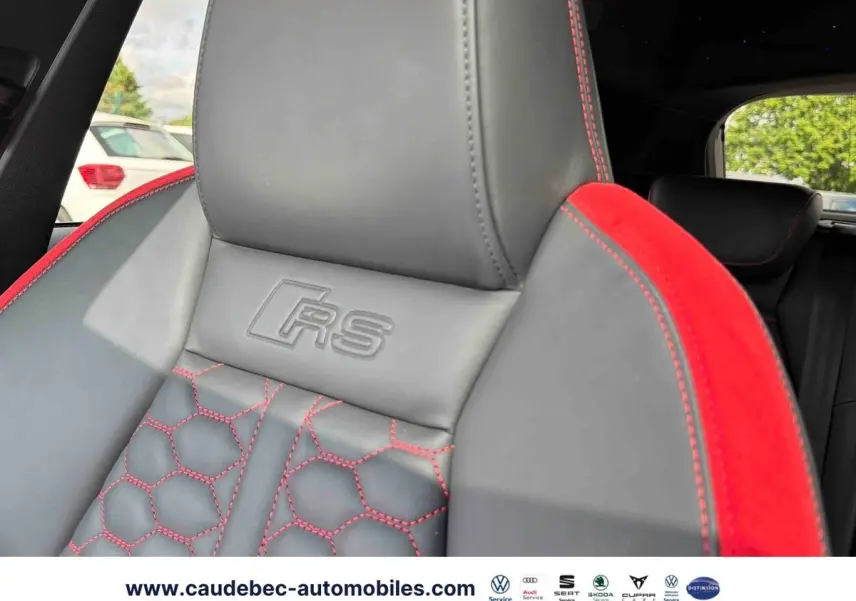 Gros plan sur le siège avant en cuir gris et alcantara rouge avec surpiqûres rouges et logo RS embossé.