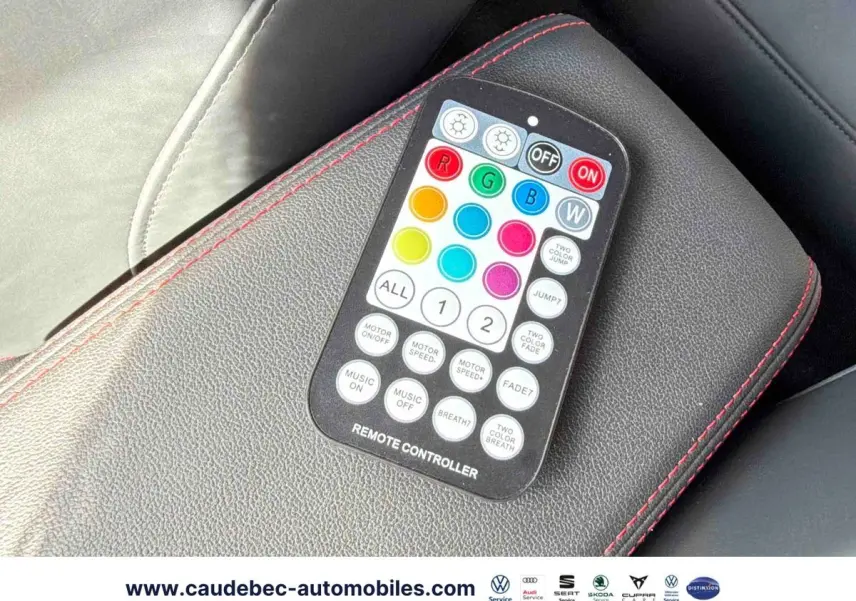 Télécommande d'éclairage multicolore posée sur un accoudoir en cuir noir avec surpiqûres rouges dans l'Audi RS3 Sportback.