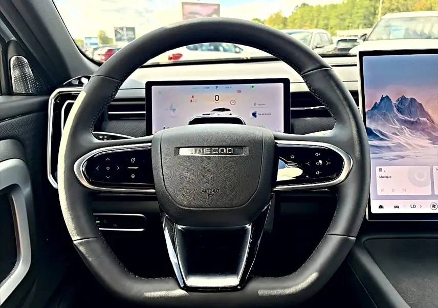 Vue intérieure centrée sur le volant noir du JAECOO J7 1.5 tgdi 224 select avec écran tactile et tableau de bord numérique.