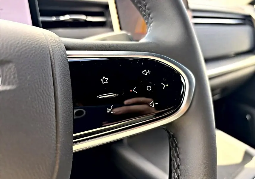 Gros plan sur les commandes multifonctions noires à touches tactiles du volant cuir noir du JAECOO J7 gris moonlight.