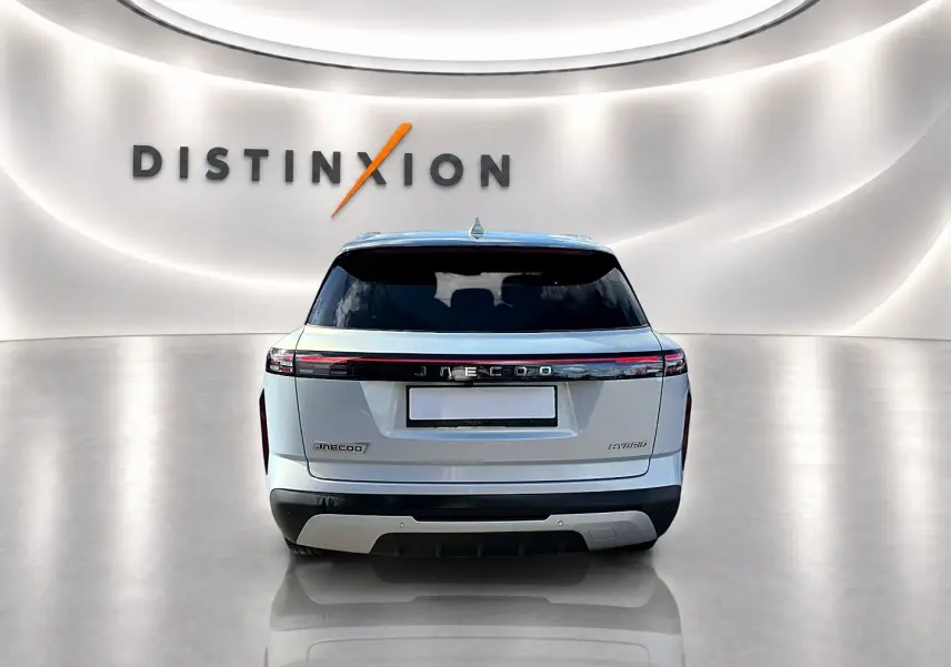 Vue arrière du SUV JAECOO J7 gris moonlight avec feux arrière à LED et toit panoramique en verre dans un showroom lumineux.