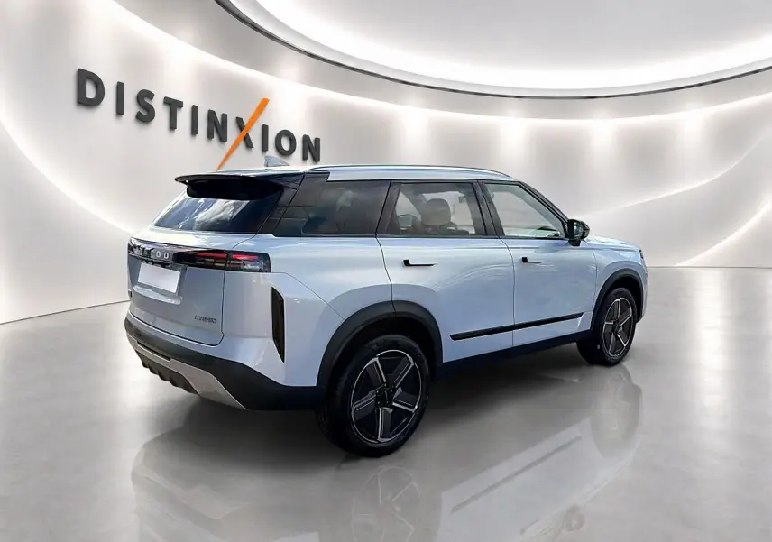 Vue 3/4 arrière droite du JAECOO J7 gris moonlight avec toit noir et jantes alu stylisées dans un showroom lumineux.