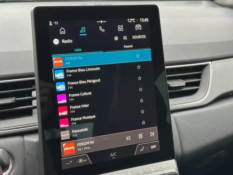 Écran tactile central du tableau de bord du Renault Captur 2025 affichant la liste des radios FM.