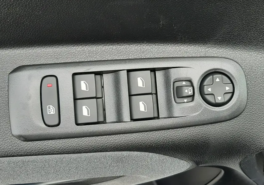 Gros plan sur les commandes de lève-vitres et réglage des rétroviseurs côté conducteur du Peugeot Rifter blanc Kaolin.