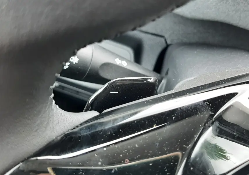 Gros plan sur la palette de changement de vitesse côté droit du volant du Peugeot Rifter blanc Kaolin, intérieur noir.