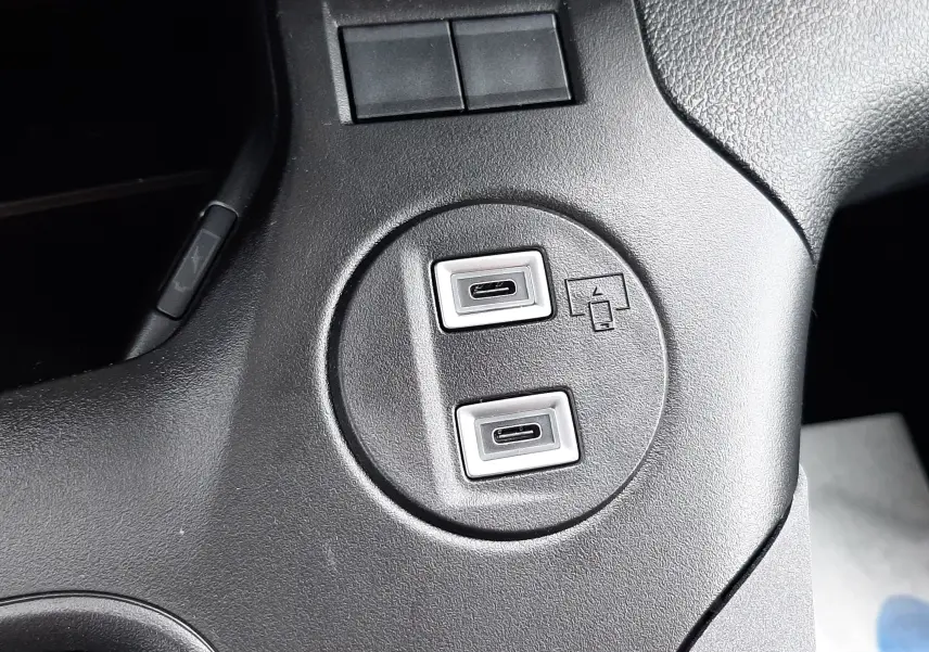 Gros plan sur les ports USB-C doubles intégrés dans la console centrale noire du Peugeot Rifter blanc Kaolin 2026.