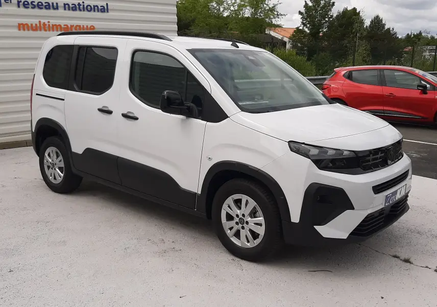 Peugeot Rifter blanc Kaolin vu en 3/4 avant droit, avec protections noires sur les bas de caisse et jantes acier.