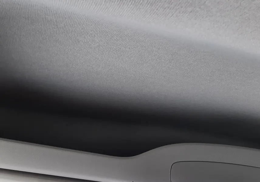 Plafond intérieur gris clair du Peugeot Rifter blanc Kaolin, vue en contre-plongée vers l'avant avec miroir intérieur visible.