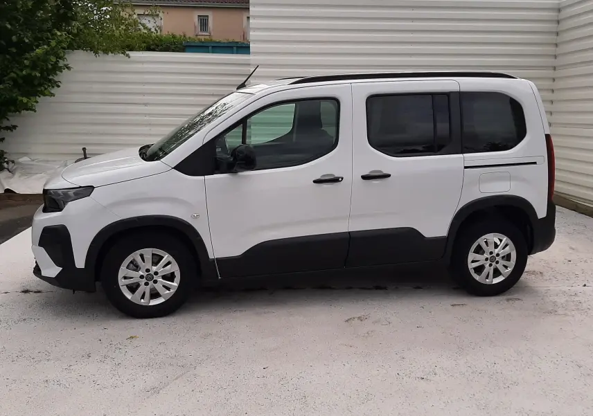 Profil droit d'un Peugeot Rifter blanc Kaolin 2026 avec vitres arrière teintées et protections noires basses.