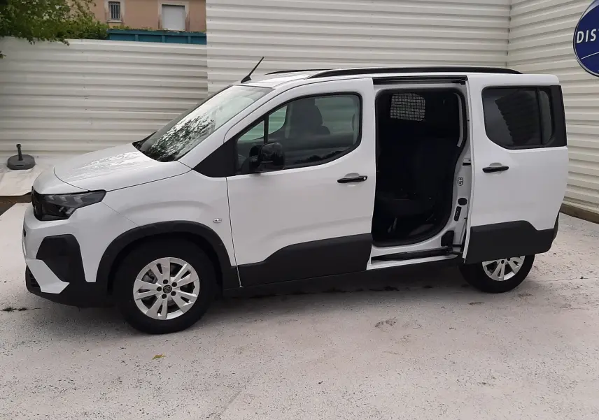 Peugeot Rifter blanc Kaolin vu de profil droit avec porte coulissante ouverte, montrant l'intérieur noir.