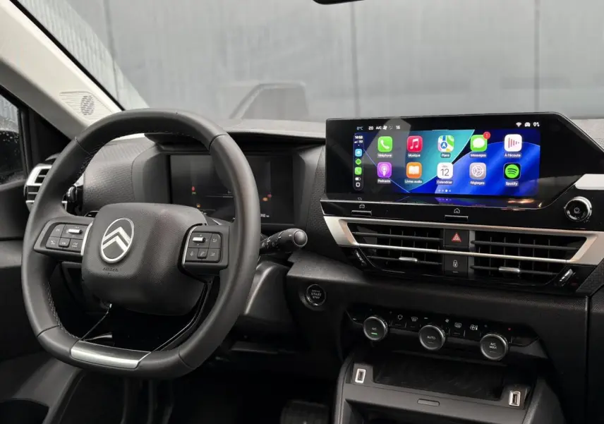 Vue intérieure du poste de conduite de la Citroën C4 Hybrid avec volant multifonction et écran tactile central lumineux.