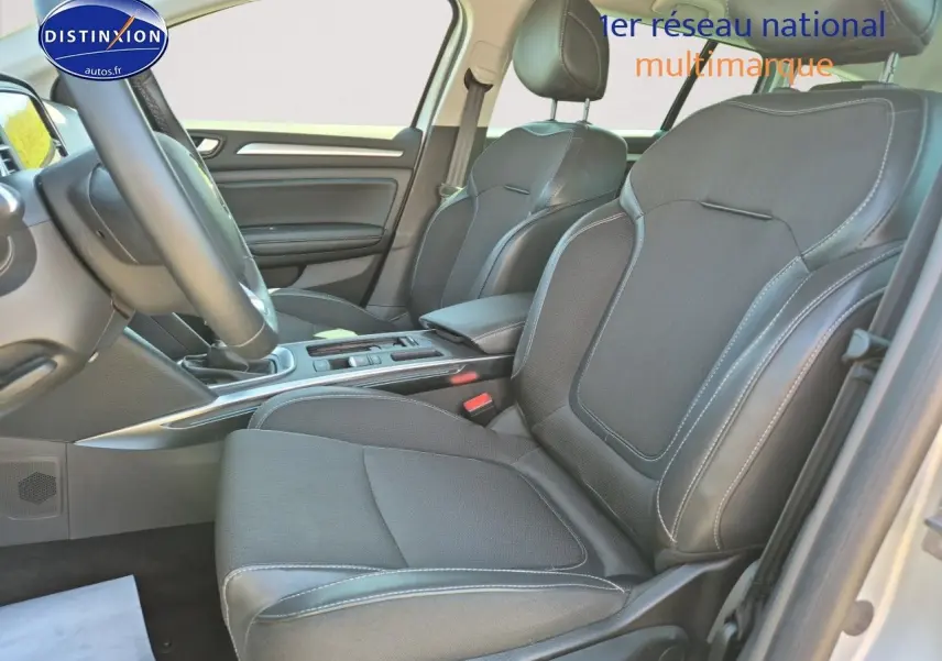 Vue intérieure côté avant droit de la Renault Mégane Break 2024, sièges tissu gris foncé avec coutures contrastées.