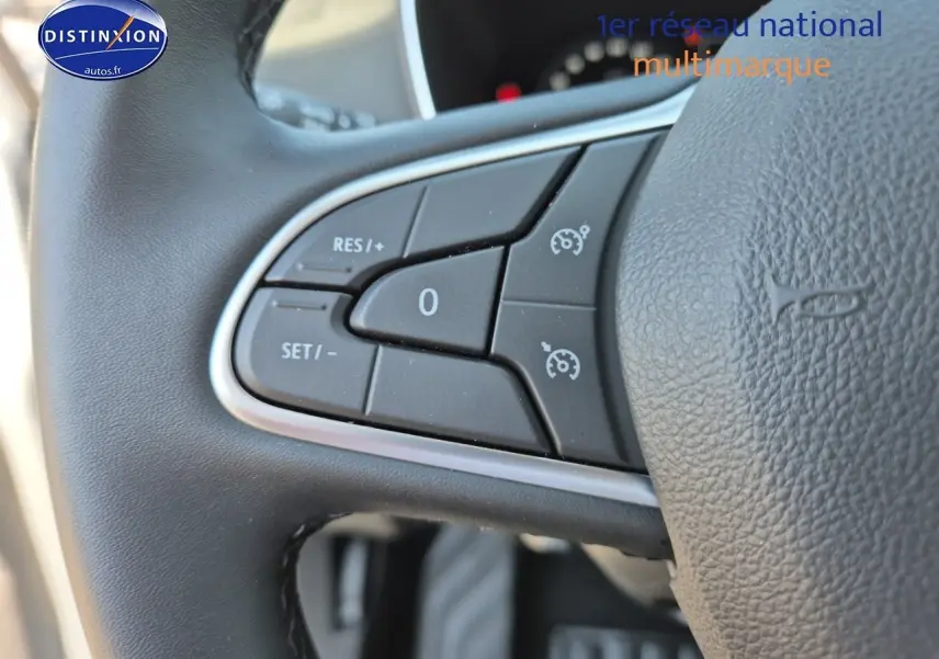 Gros plan sur les commandes de régulateur de vitesse au volant noir du Renault Mégane Break Gris Titanium 2024.