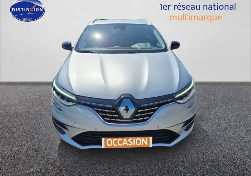 Vue frontale d'une Renault Mégane Break gris Titanium 2024 avec phares LED et calandre noire distinctive.