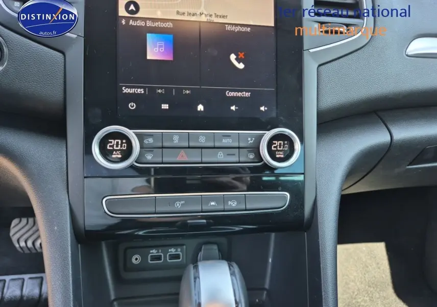 Vue rapprochée de la console centrale de la Renault Mégane Break 2024 gris Titanium, avec écran tactile et commandes climatisation.