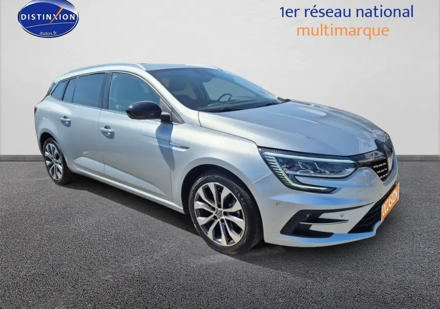 Renault Mégane Break gris titanium vue 3/4 avant droit avec jantes alliage et barres de toit.