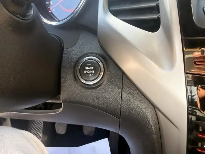 Gros plan sur le bouton Start Engine Stop du tableau de bord noir et gris du SsangYong Tivoli 2017.